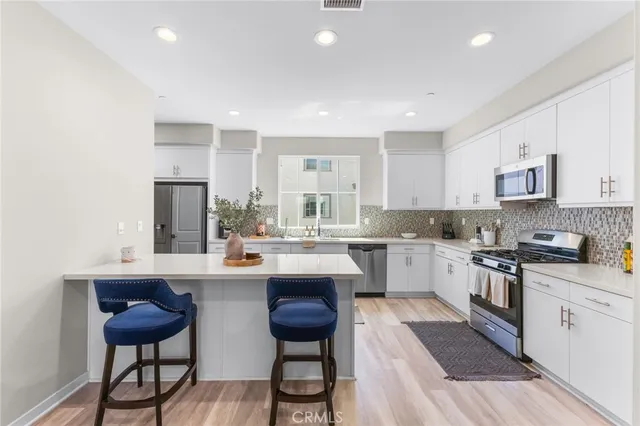 a kitchen with stainless steel appliances kitchen island granite countertop a sink and cabinets