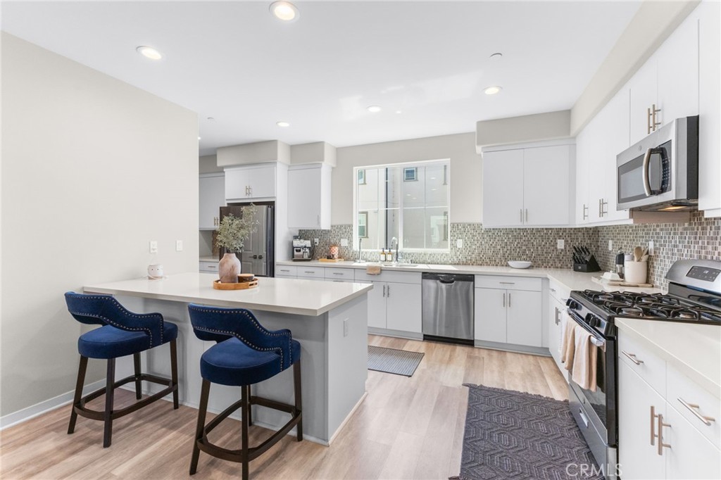 45763 Via Nubes Temecula, CA 92592 - Photo 24 of 63 a kitchen with stainless steel appliances kitchen island granite countertop a sink and cabinets