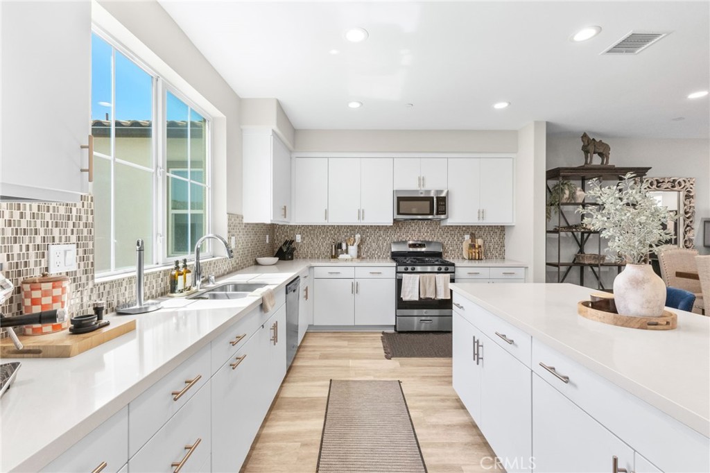 45763 Via Nubes Temecula, CA 92592 - Photo 28 of 63 a large kitchen with a large window and stainless steel appliances