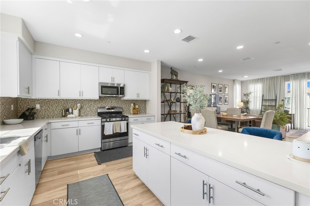 45763 Via Nubes Temecula, CA 92592 - Photo 29 of 63 a kitchen with a sink stainless steel appliances and white cabinets