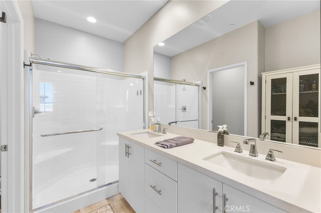 45763 Via Nubes Temecula, CA 92592 - Photo 36 of 63 a bathroom with a double vanity sink mirror and shower
