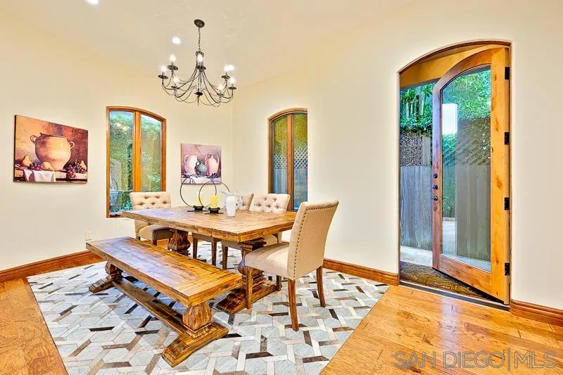 7964 Prospect Place La Jolla, CA 92037 - Photo 14 of 46 a dining room with chandelier and wooden floor
