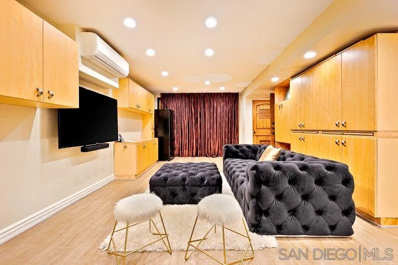 7964 Prospect Place La Jolla, CA 92037 - Photo 30 of 46 a spacious bedroom with a bed and a flat screen tv