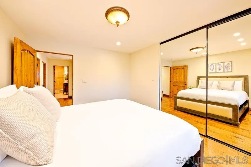 7964 Prospect Place La Jolla, CA 92037 - Photo 36 of 46 a spacious bedroom with a bed and closet with mirror