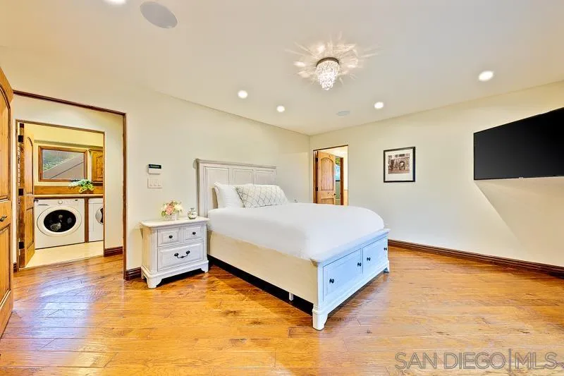 7964 Prospect Place La Jolla, CA 92037 - Photo 38 of 46 a bedroom with a bed and a flat tv screen on dresser