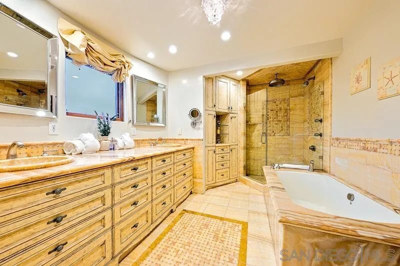 7964 Prospect Place La Jolla, CA 92037 - Photo 40 of 46 a bathroom with a granite countertop double vanity sink a mirror and a bathtub