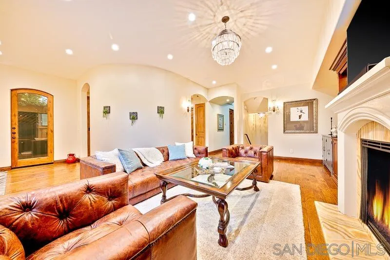 7964 Prospect Place La Jolla, CA 92037 - Photo 7 of 46 a living room with furniture a fireplace and a flat screen tv