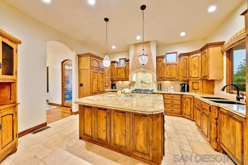 7964 Prospect Place La Jolla, CA 92037 - Photo 9 of 46 a large kitchen with kitchen island a large counter top space a sink a refrigerator and cabinets