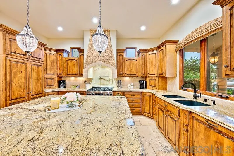 7964 Prospect Place La Jolla, CA 92037 - Photo 10 of 46 a large kitchen with kitchen island granite countertop a sink and cabinets