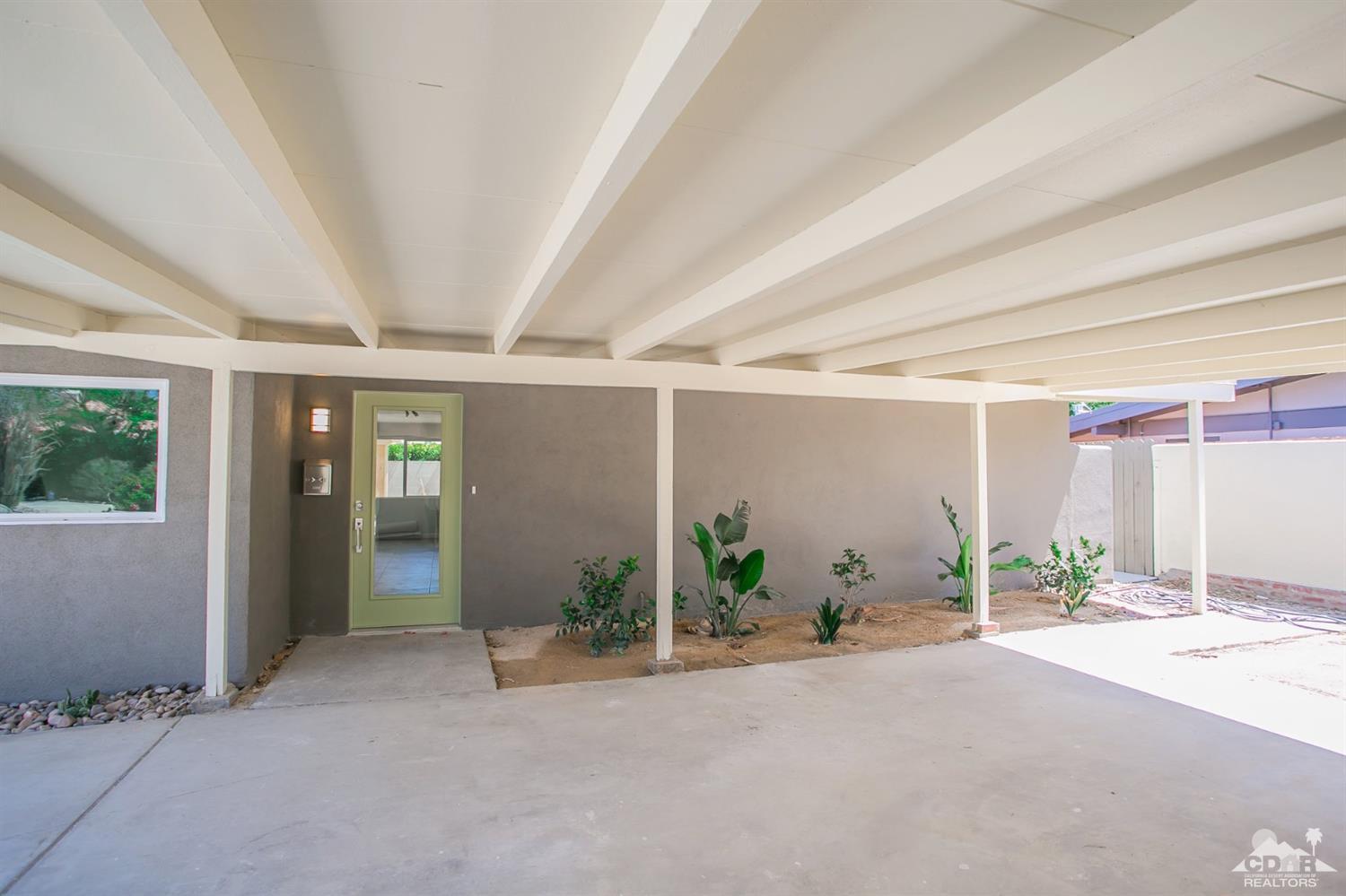 71933 Vista Del Rio Rancho Mirage, CA 92270 - Photo 5 of 32 an empty room with potted plants and a large window
