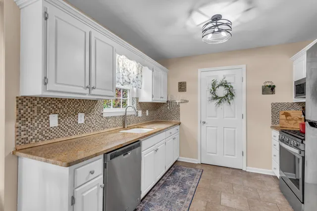 a kitchen with stainless steel appliances granite countertop a sink stove and cabinets