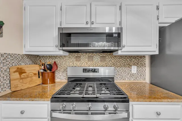 a kitchen with granite countertop a stove and a sink