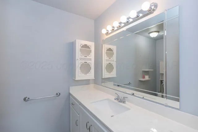 a bathroom with a sink vanity and a mirror