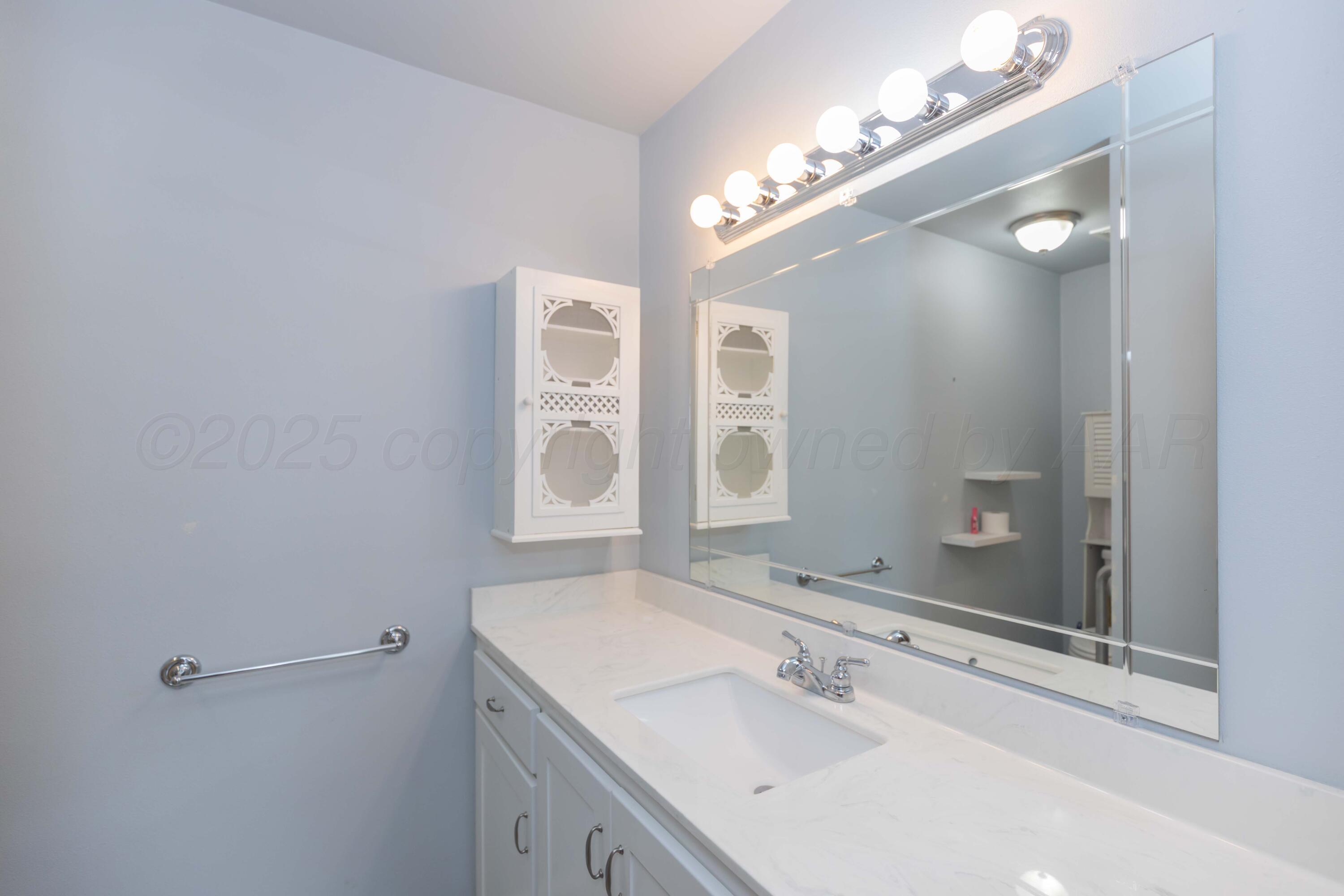 7000 Sunburst Street Amarillo, TX 79110 - Photo 13 of 32 a bathroom with a sink vanity and a mirror