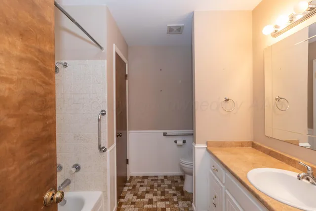 a bathroom with a granite countertop sink toilet and shower