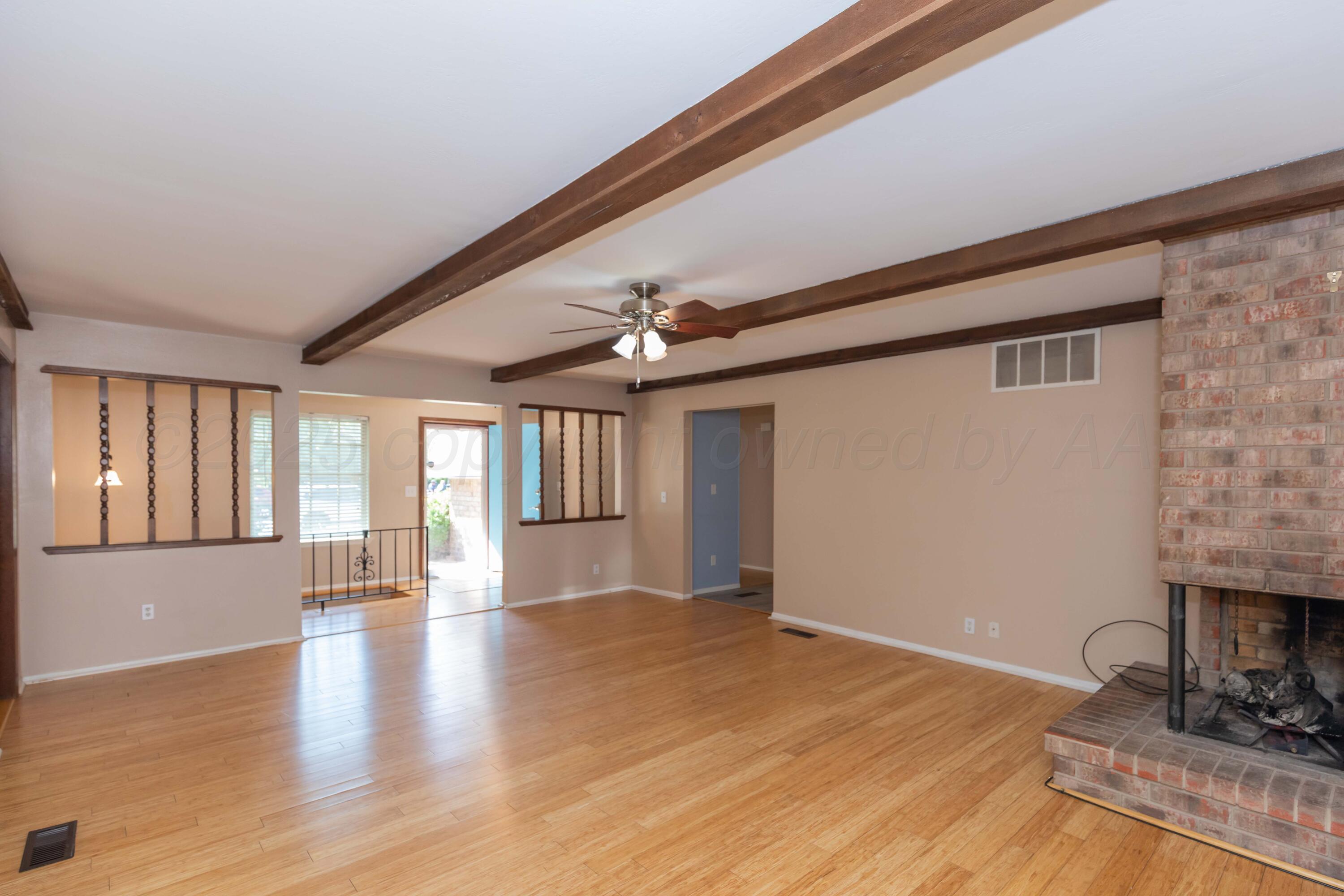 7000 Sunburst Street Amarillo, TX 79110 - Photo 2 of 32 a view of an empty room with a window and wooden floor