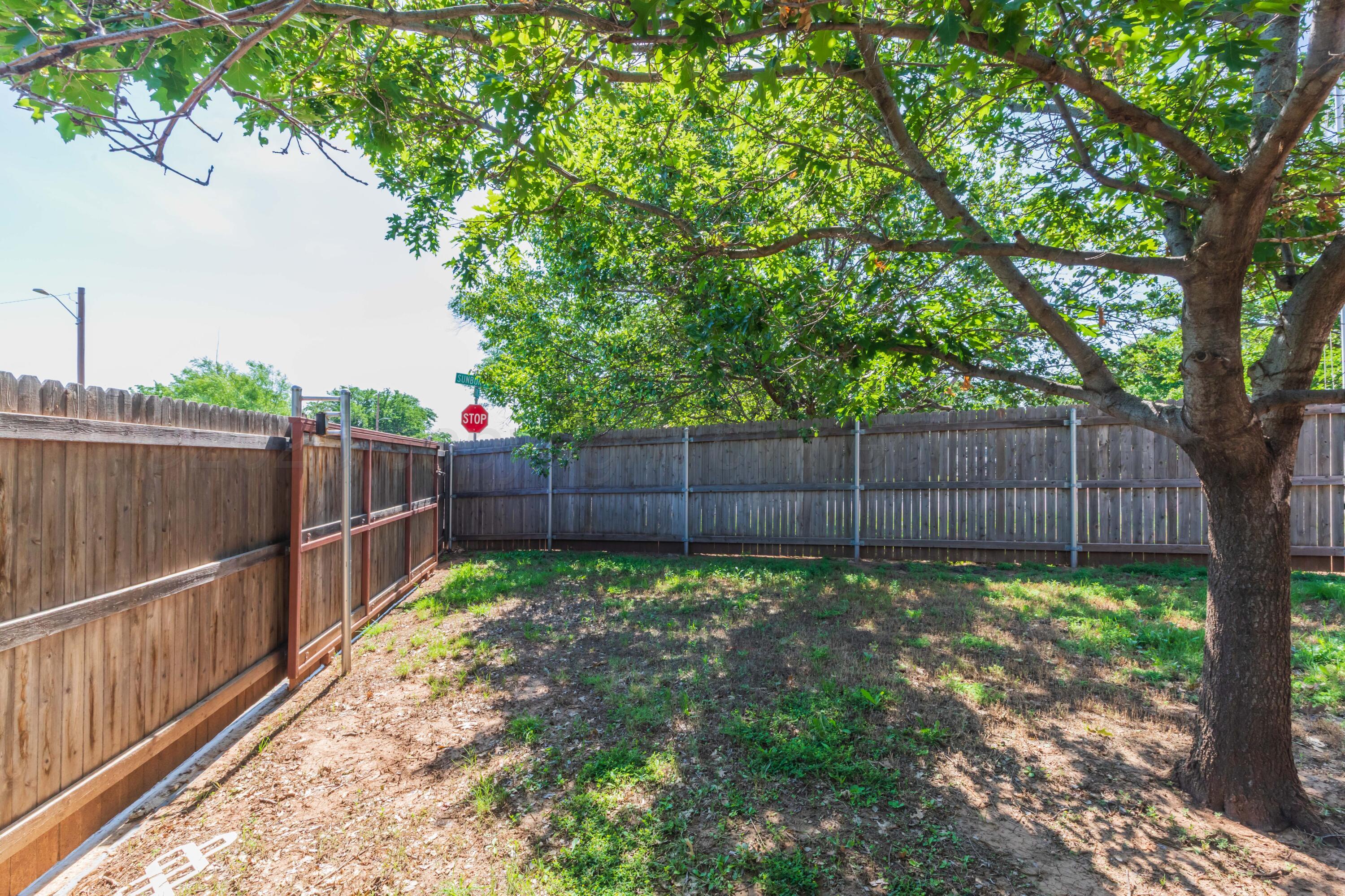 7000 Sunburst Street Amarillo, TX 79110 - Photo 29 of 32 a view of a backyard with wooden fence and a large tree