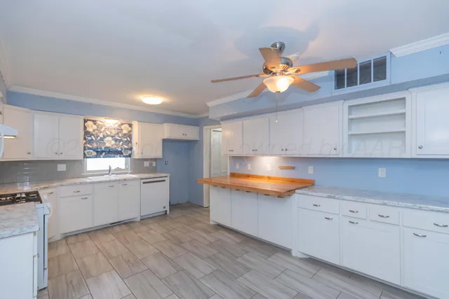 a kitchen with granite countertop a sink cabinets and stainless steel appliances