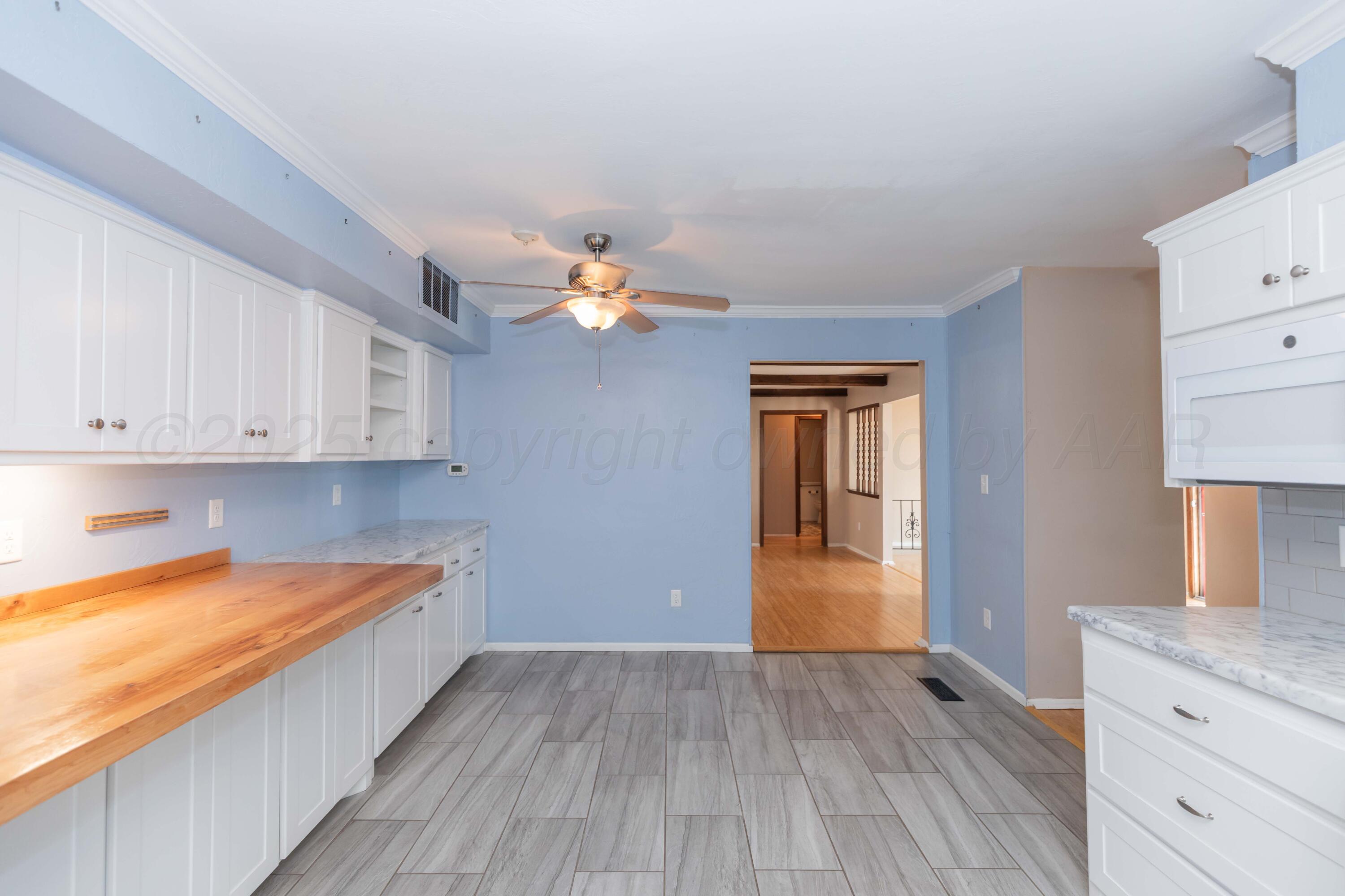 7000 Sunburst Street Amarillo, TX 79110 - Photo 6 of 32 a view of a kitchen with a sink and dishwasher with wooden floor