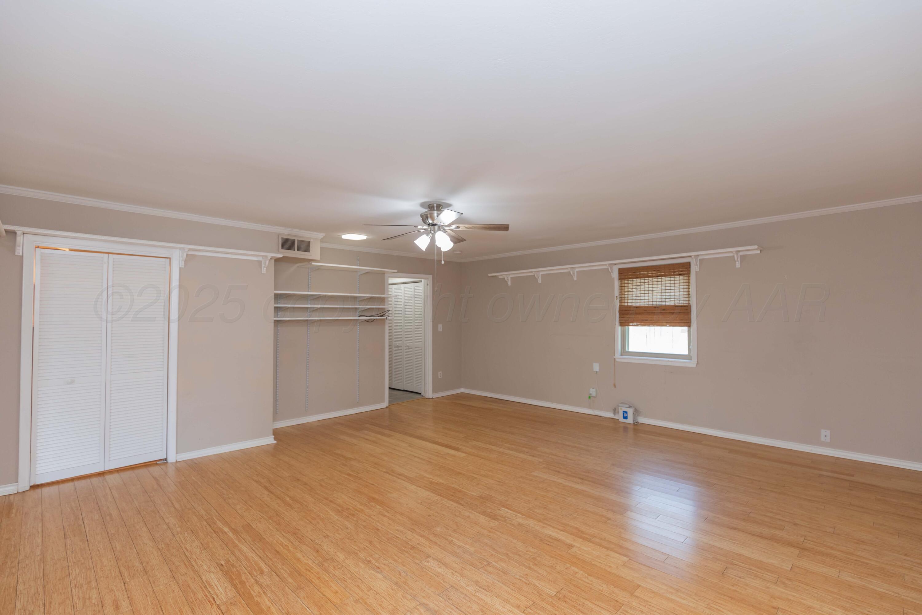 7000 Sunburst Street Amarillo, TX 79110 - Photo 9 of 32 wooden floor in an empty room with a window