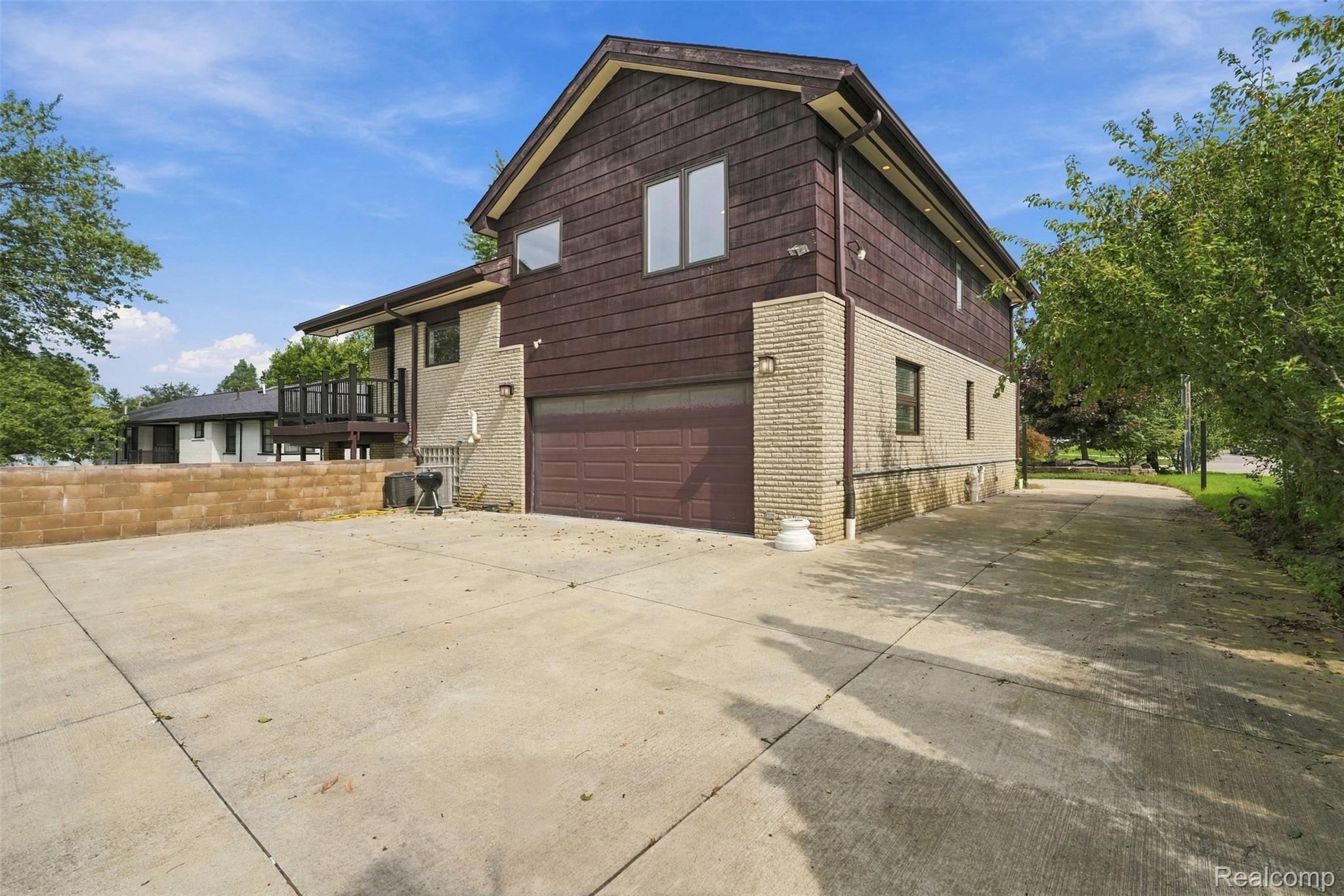 27507 Bell Road Southfield, MI 48034 - Photo 55 of 81 Two-story exterior with a shingle and stucco facade, an attached garage, and a concrete driveway