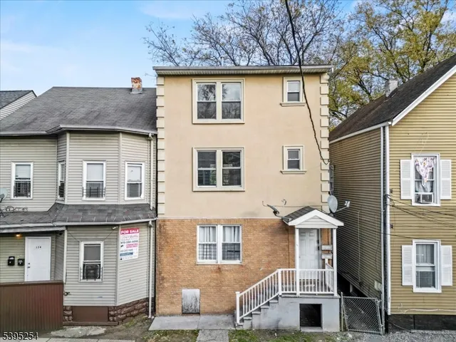 a view of a house with a yard and large tree