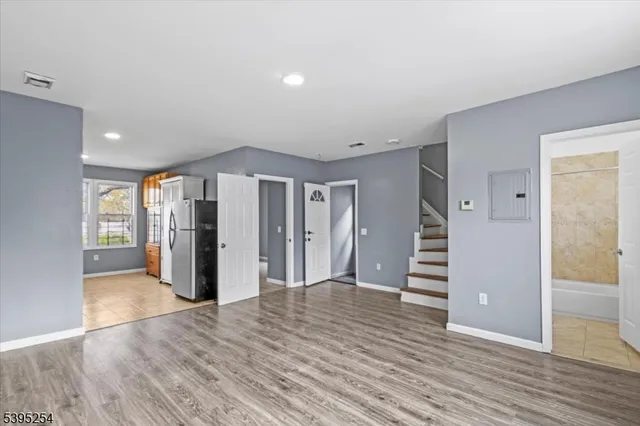 an empty room with wooden floor and entryway