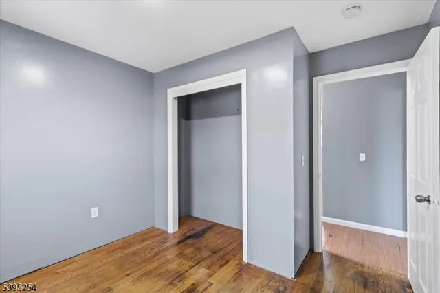 an empty room with wooden floor and closet