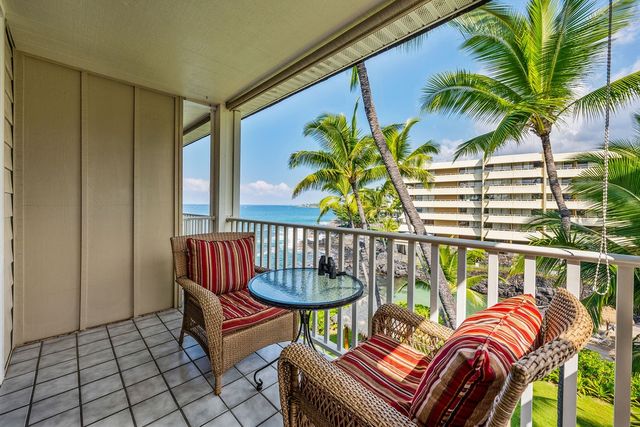 a balcony with furniture and a potted plant