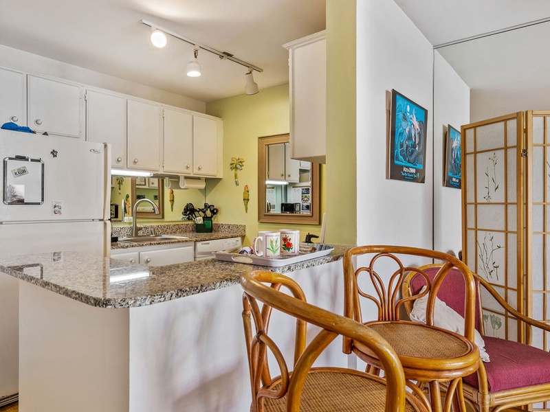 75-5870 Kahakai Road, Unit 409 Kailua-Kona, HI 96740 - Photo 11 of 16 a kitchen with stainless steel appliances granite countertop a dining table and chairs