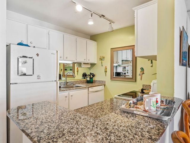 a kitchen with granite countertop a sink stove and refrigerator