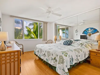 a bedroom with a bed and a large window with the outer view