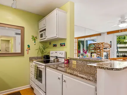 a kitchen with stainless steel appliances granite countertop a sink and a stove next to a window