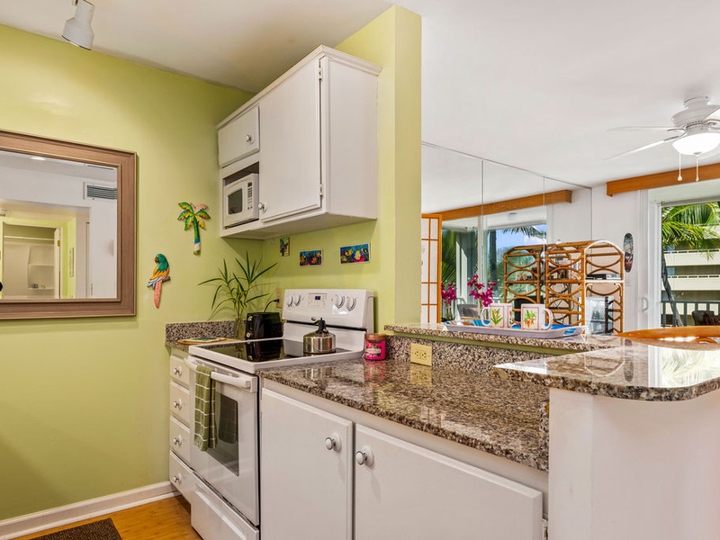 75-5870 Kahakai Road, Unit 409 Kailua-Kona, HI 96740 - Photo 6 of 16 a kitchen with stainless steel appliances granite countertop a sink and a stove next to a window