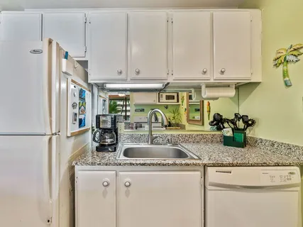 a kitchen with granite countertop a refrigerator a stove and a sink