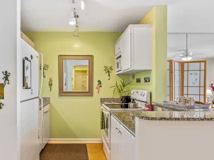 a kitchen with stainless steel appliances granite countertop a sink a stove and a refrigerator