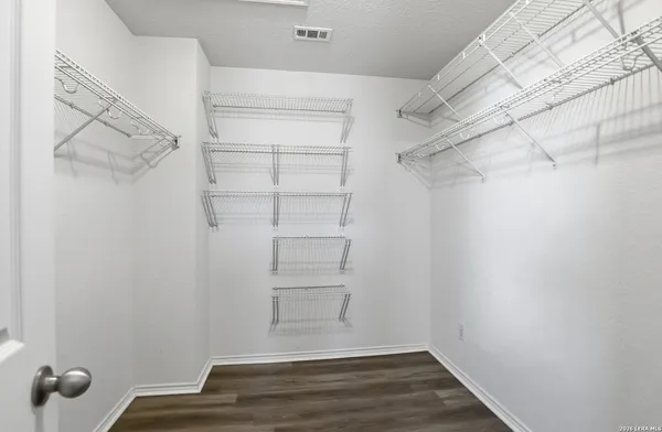 a view of walk in closet with empty racks