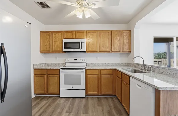 a kitchen with stainless steel appliances granite countertop a sink stove and microwave