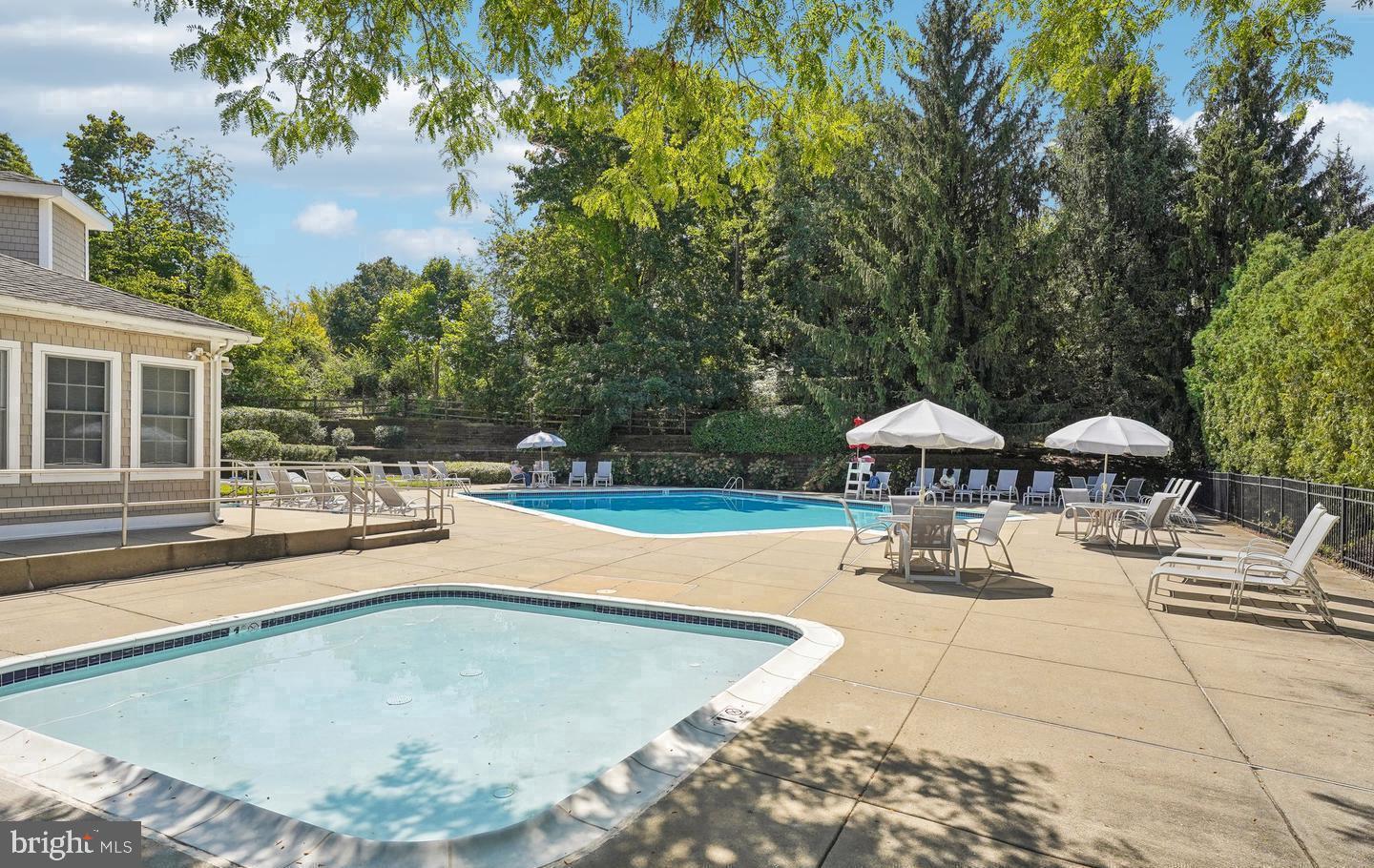 31 Ashley Court, Unit 31 Glen Mills, PA 19342 - Photo 17 of 19 a view of a swimming pool with lawn chairs under an umbrella