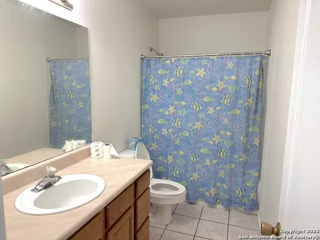 a bathroom with a sink a toilet and shower curtain