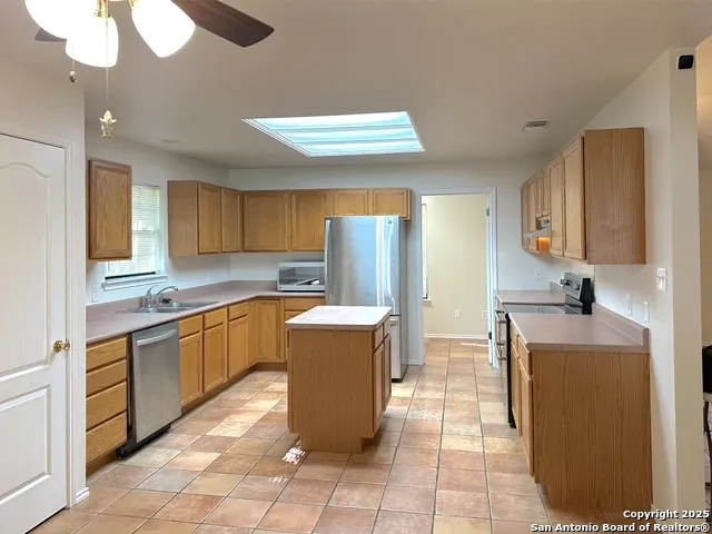 a kitchen with stainless steel appliances granite countertop a sink counter space cabinets and a window