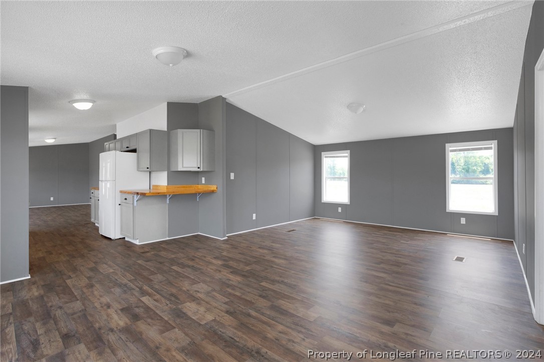 152 Three Bridges Road Rowland, NC 28383 - Photo 23 of 27 a view of empty room with wooden floor and kitchen