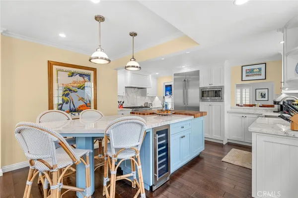 a view of a dining room with furniture a kitchen and chandelier
