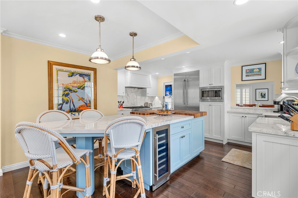 112 Abalone Avenue Newport Beach, CA 92662 - Photo 11 of 25 a view of a dining room with furniture a kitchen and chandelier