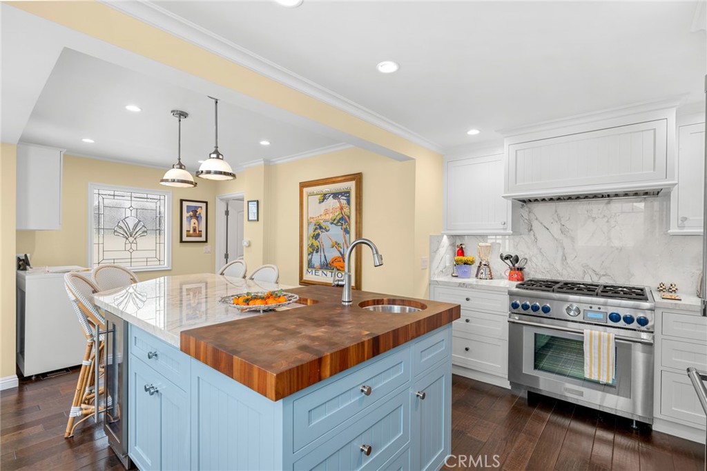 112 Abalone Avenue Newport Beach, CA 92662 - Photo 10 of 25 a kitchen with a stove a sink a kitchen island with wooden cabinets and floor