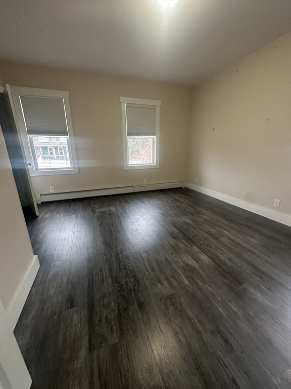 105 Elm Street, Unit 1 Gardner, MA 01440 - Photo 3 of 9 an empty room with wooden floor and windows