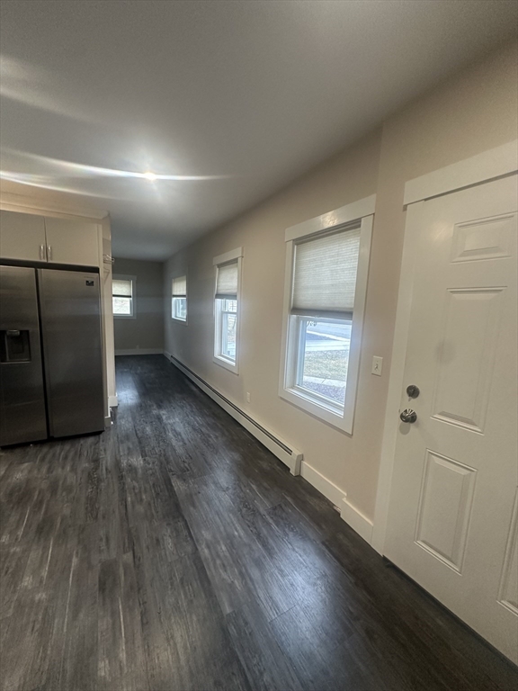 105 Elm Street, Unit 1 Gardner, MA 01440 - Photo 5 of 9 an empty room with wooden floor and windows