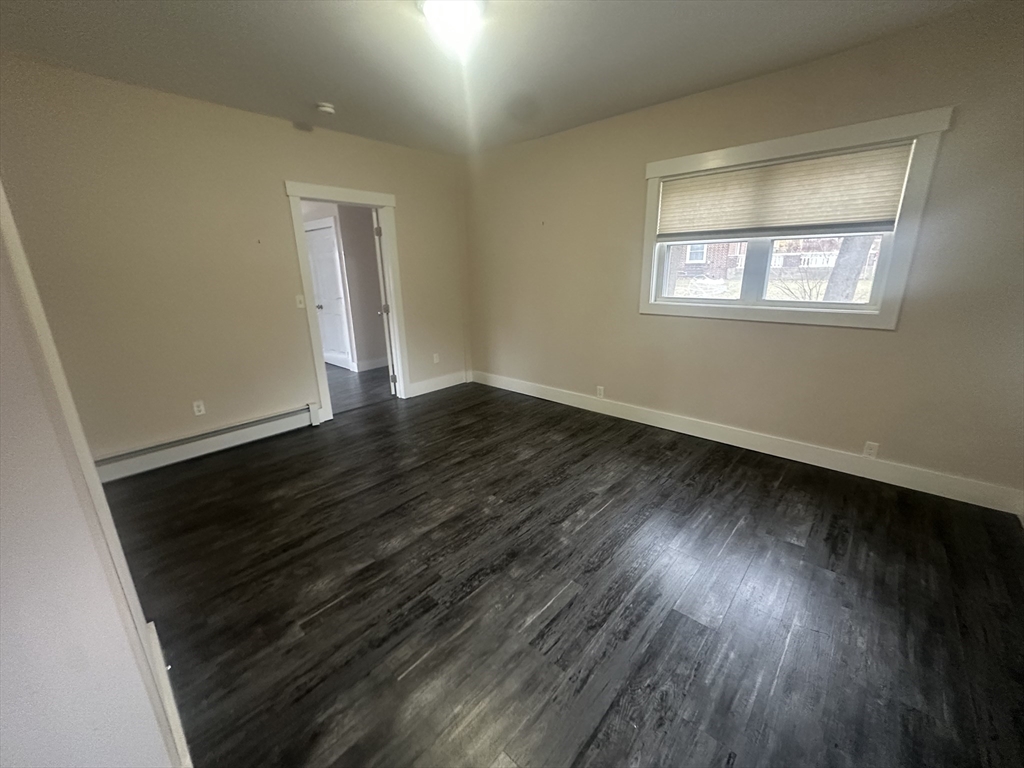 105 Elm Street, Unit 1 Gardner, MA 01440 - Photo 7 of 9 a view of an empty room with wooden floor and a window