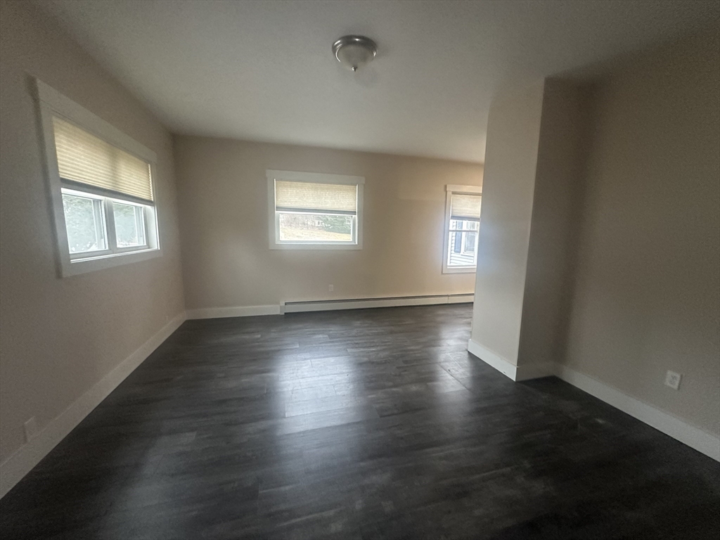 105 Elm Street, Unit 1 Gardner, MA 01440 - Photo 9 of 9 an empty room with wooden floor and windows