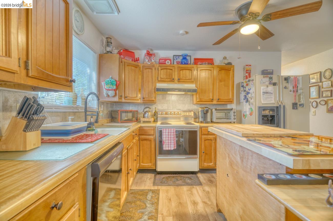 19215 Ferretti Road Groveland, CA 95321 - Photo 12 of 40 Kitchen featuring wood-finish cabinetry, a tile backsplash, and wood-finish flooring